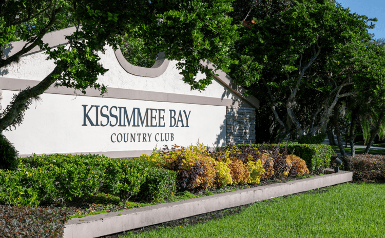 View of Kissimme Bay Country Club entrance sign with lush greenery